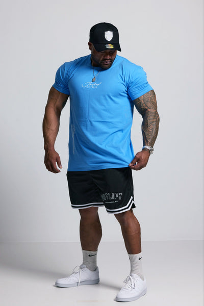 Person wearing a blue t-shirt, black shorts, and white sneakers on a plain background