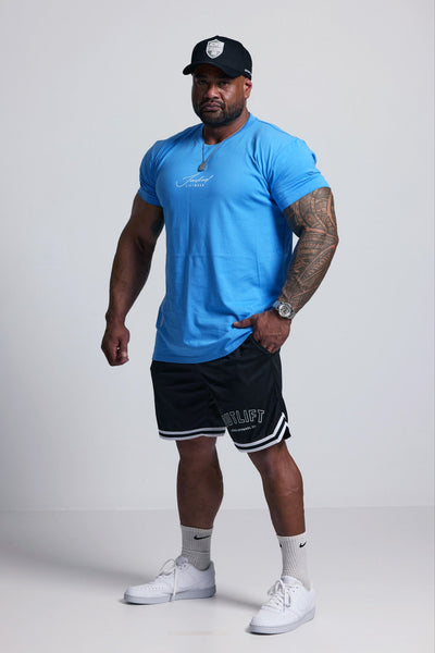 Man wearing a blue athletic shirt, black shorts, and white sneakers on a white background