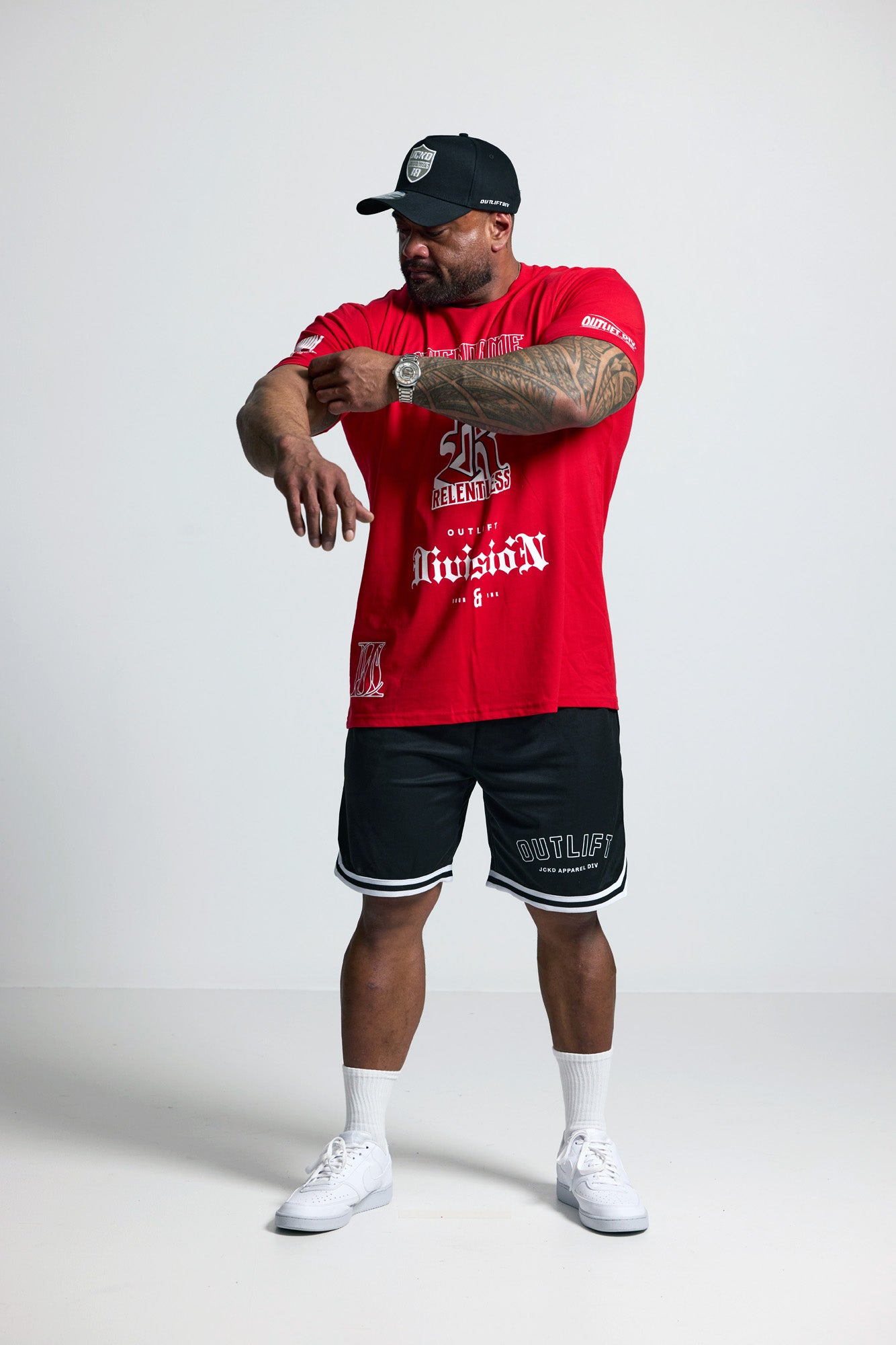 Person wearing a red sports jersey and black shorts on a white background
