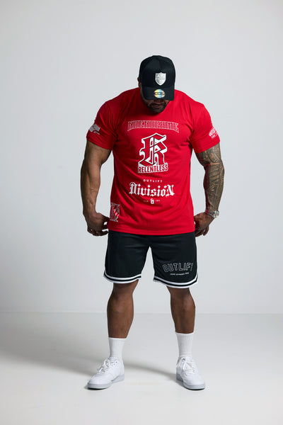 Person wearing a red t-shirt, black shorts, and white sneakers on a plain background