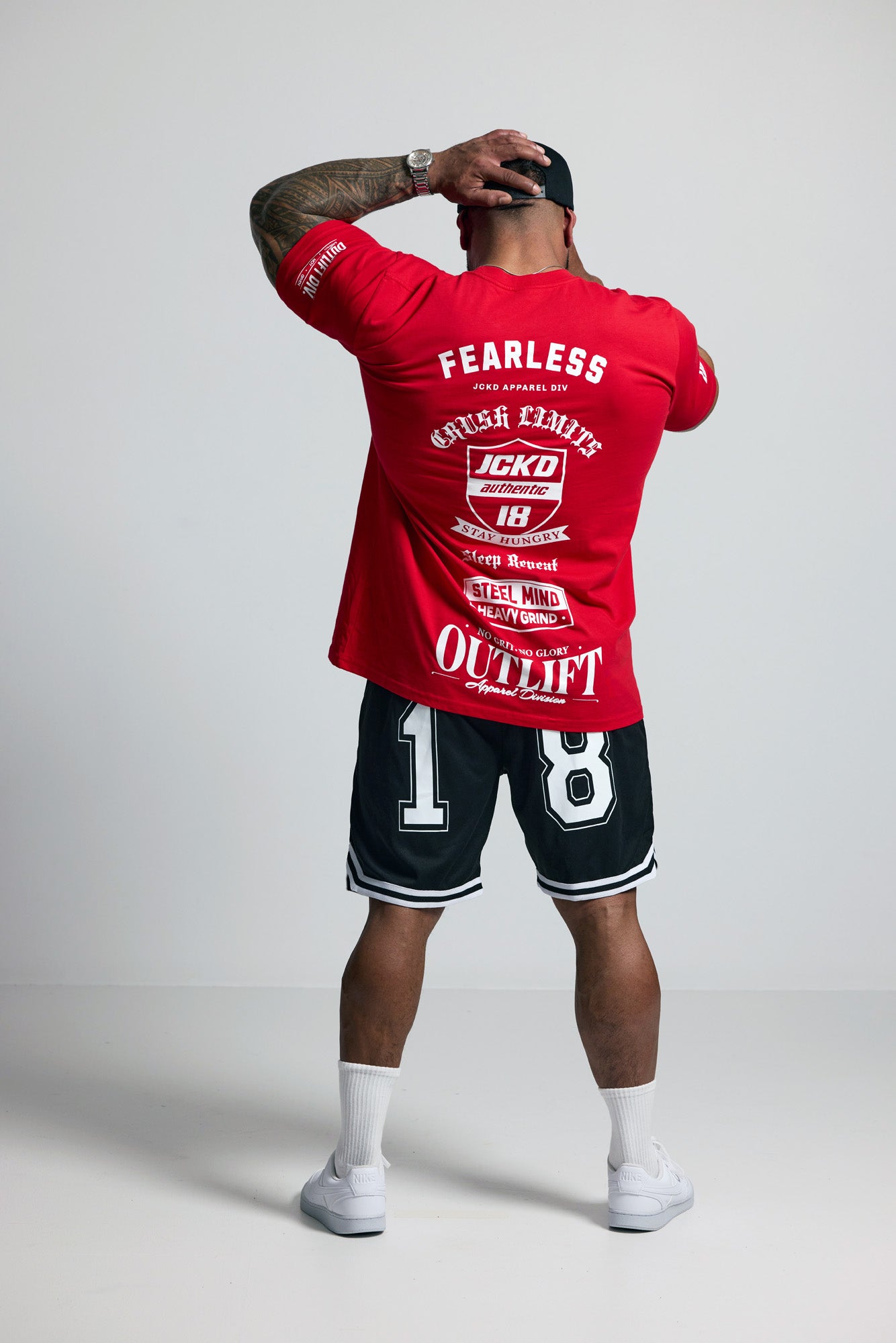 Person wearing a red 'Fearless' t-shirt and black shorts with white text on a plain background
