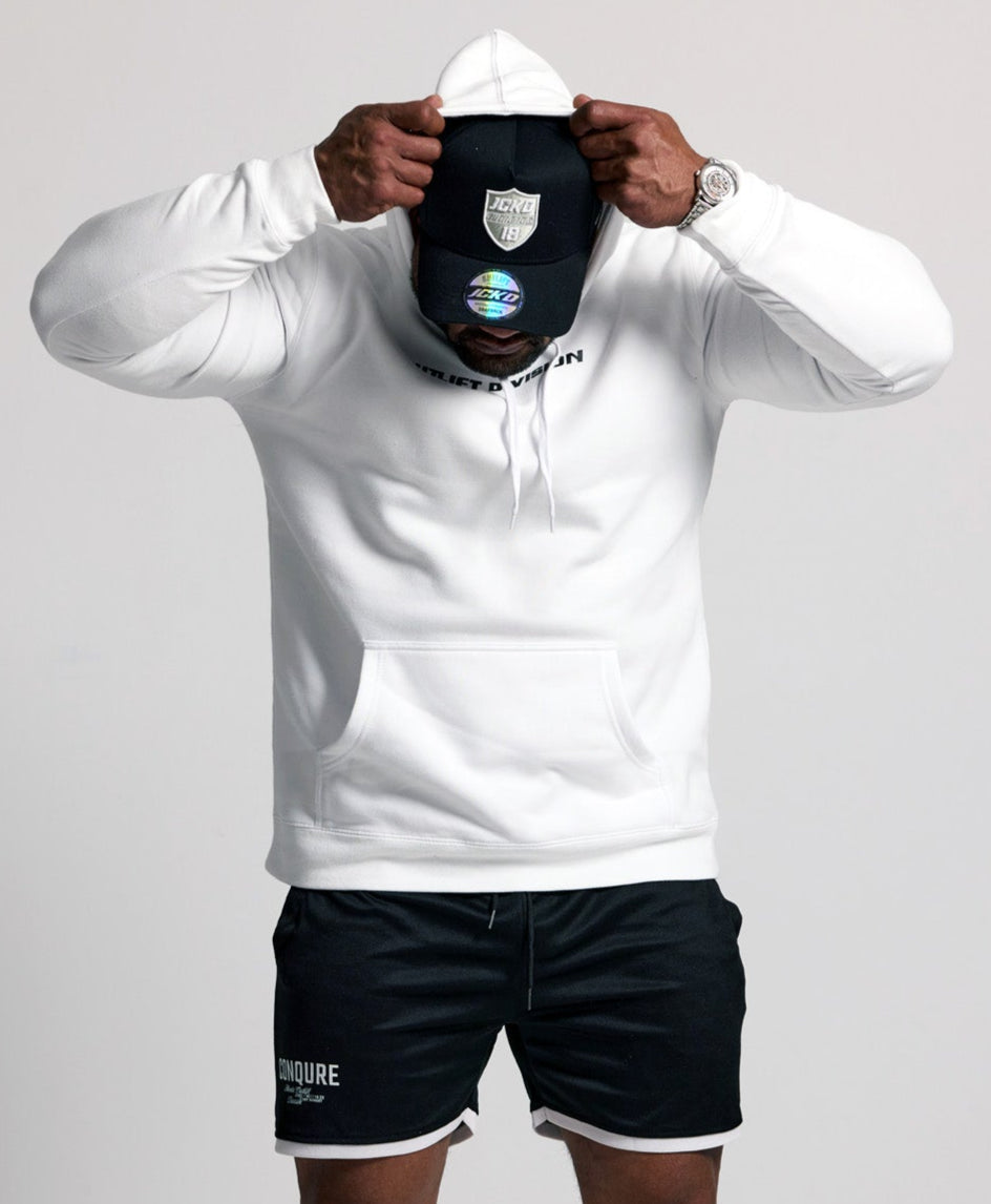 Person wearing a white hoodie, black shorts, and white sneakers on a plain background