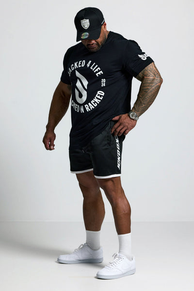 Person wearing a black t-shirt and shorts with visible branding on a white background