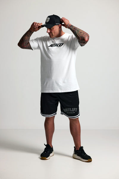 Person wearing a white t-shirt with black text and black shorts with white text, standing against a plain background.